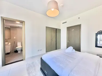 a bedroom with a large bed and a bathroom at EasyGo - Elegant 1BR in Downtown Dubai in Dubai