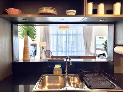 a kitchen with a sink and a palm tree in the mirror at EasyGo - Elegant 1BR in Downtown Dubai in Dubai