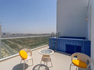 a room with chairs and a table and a fireplace at Velvet Luxe Modern - 1BR w Private Pool in Gemz-15 in Dubai