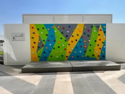 a wall with a climbing wall in a building at Velvet Luxe Modern - 1BR w Private Pool in Gemz-15 in Dubai