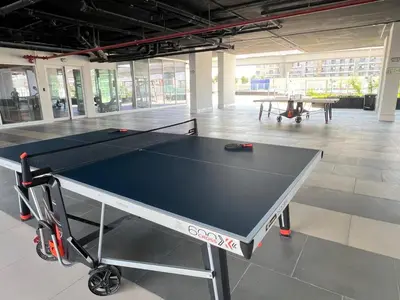 a ping pong table in the middle of a room at Velvet Luxe Modern - 1BR w Private Pool in Gemz-15 in Dubai