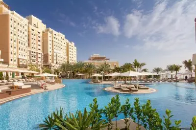 a large pool with chairs and umbrellas in a resort at Luxury Palm Jumeirah Apartment with Sea Views Balqis Residence in Dubai