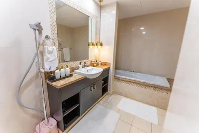 a bathroom with a sink and a mirror and a tub at Luxury Palm Jumeirah Apartment with Sea Views Balqis Residence in Dubai