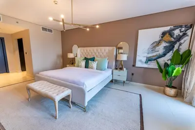 a bedroom with a bed and a bench in it at Luxury Palm Jumeirah Apartment with Sea Views Balqis Residence in Dubai