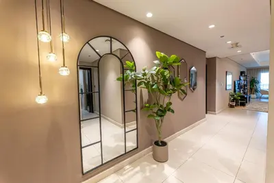 a hallway with a mirror and a plant at Luxury Palm Jumeirah Apartment with Sea Views Balqis Residence in Dubai