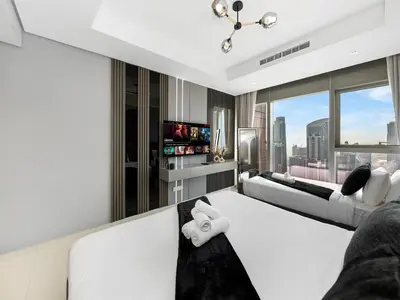 a bedroom with white furniture and a view of the city at Famous Sky Pool - Paramount Midtown - Dubai Skyline Views in Dubai
