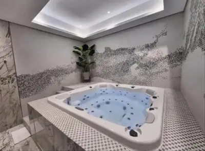 a bathroom with a bath tub with a painting on the wall at Famous Sky Pool - Paramount Midtown - Dubai Skyline Views in Dubai