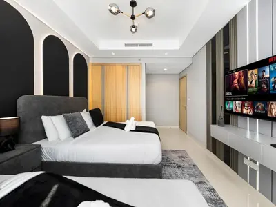 a bedroom with two beds and a flat screen tv at Famous Sky Pool - Paramount Midtown - Dubai Skyline Views in Dubai