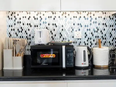 a microwave sitting on a counter in a kitchen at Famous Sky Pool - Paramount Midtown - Dubai Skyline Views in Dubai