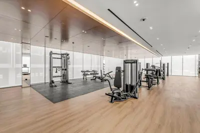 a gym with treadmills and exercise equipment in a building at Charming Studio in Binghatti Galaxy JVC in Dubai