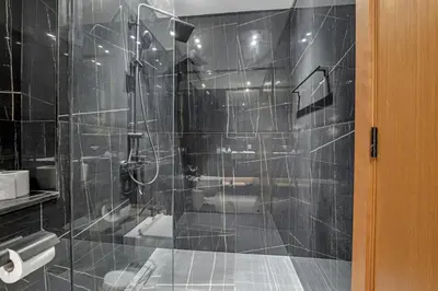 a bathroom with a shower with a glass door at Charming Studio in Binghatti Galaxy JVC in Dubai