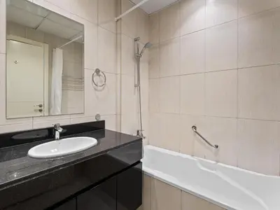 a bathroom with a sink and a mirror and a tub at Glamorous Luxe Studio in Ghalia-JVC-12 in Dubai