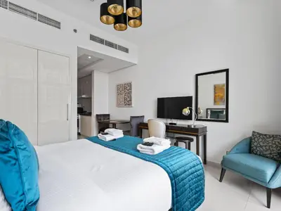 a bedroom with a bed and two chairs and a desk at Glamorous Luxe Studio in Ghalia-JVC-12 in Dubai