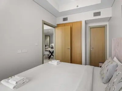 a bedroom with a white bed with a mirror at Sophisticated 2BDR Living In Aykon City Business B in Dubai