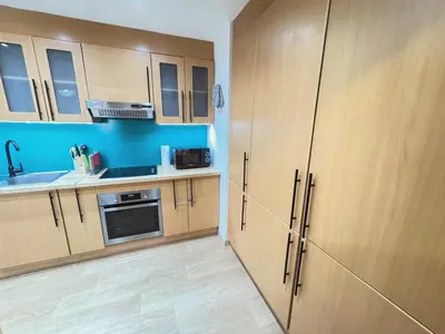 a kitchen with wooden cabinets and a sink at JBR l Full Sea View l 4BR l 3min to Beach l 7-12PAX in Dubai