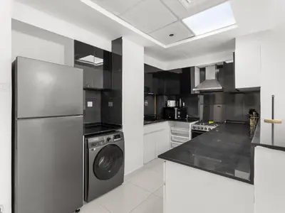 a kitchen with a refrigerator and a dishwasher at Signature Prestige 1BR Sleeps 4 -Damac Central in Dubai