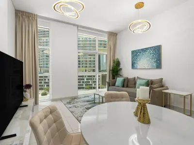 a living room with a table and a couch at Signature Prestige 1BR Sleeps 4 -Damac Central in Dubai