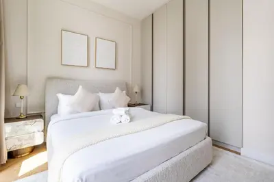 a bedroom with a white bed with two teddy bears on it at New! Elegant 1BR Flat in Creek Harbour with Pool&Gym in Dubai