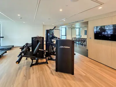 a gym with a exercise bike and a television at New! Elegant 1BR Flat in Creek Harbour with Pool&Gym in Dubai