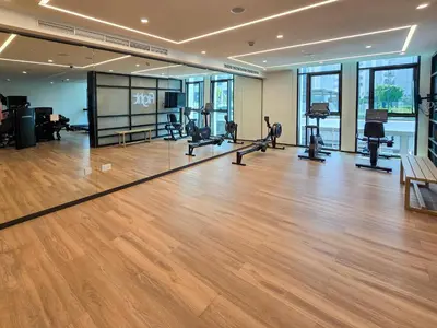 a gym with a wooden floor and treadmills at New! Elegant 1BR Flat in Creek Harbour with Pool&Gym in Dubai