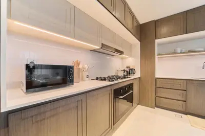a kitchen with wooden cabinets and a microwave at Luxury 3BR Marina View at Palace Beach Residence in Dubai