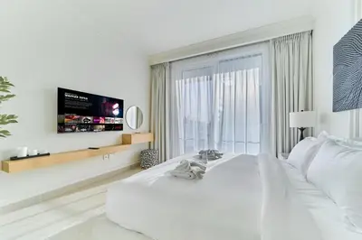 a white bedroom with a large bed and a large window at Luxury 3BR Marina View at Palace Beach Residence in Dubai
