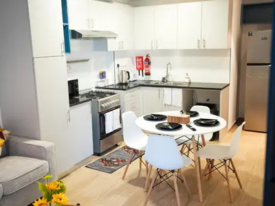 a kitchen with a table and chairs in a kitchen at 2BR Next to Metro and EXPO City GYM Pool Playground in Dubai