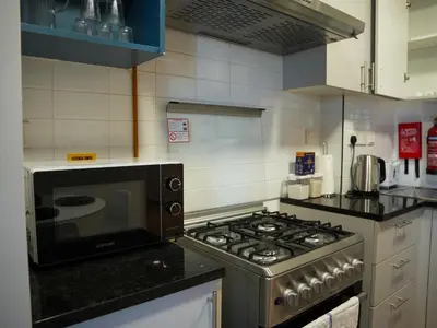 a kitchen with a stove and a microwave at 2BR Next to Metro and EXPO City GYM Pool Playground in Dubai