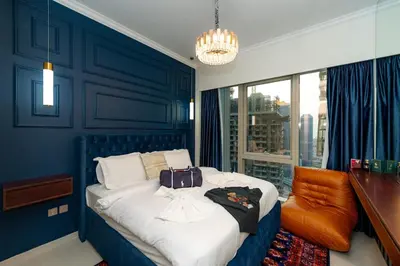 a blue bedroom with a bed with a suitcase on it at Polo Bar DXB a High Floor 1BDR in Downtown Dubai in Dubai