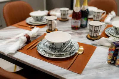 a table with plates and cups on top of it at Polo Bar DXB a High Floor 1BDR in Downtown Dubai in Dubai