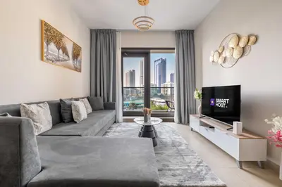 a living room with a couch and a tv at New! Serene 2BR with Balcony & Pool in Sparkle Tower in Dubai