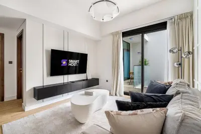a living room with a couch and a tv at New! Stylish 1BR with Balcony and Pool Elysee III JVC in Dubai