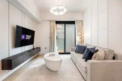 a living room with a couch and a tv at New! Stylish 1BR with Balcony and Pool Elysee III JVC in Dubai