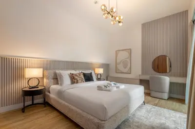 a bedroom with a large white bed and a chandelier at New! Stylish 1BR with Balcony and Pool Elysee III JVC in Dubai