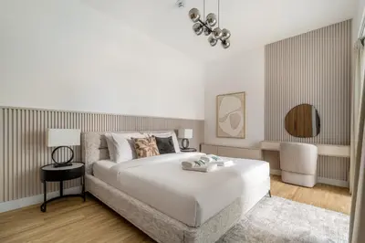 a bedroom with a large white bed and a chair at New! Stylish 1BR with Balcony and Pool Elysee III JVC in Dubai