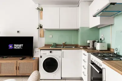 a kitchen with a washing machine and a sink at New! Serene Studio with Balcony and Pool Crystal Res in Dubai