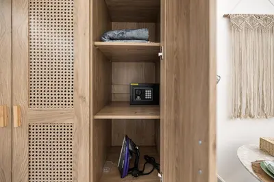 a wooden cabinet with a microwave in a room at New! Serene Studio with Balcony and Pool Crystal Res in Dubai