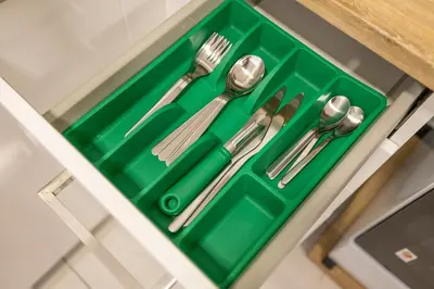 a green tray with cutlery in a drawer at New! Serene Studio with Balcony and Pool Crystal Res in Dubai