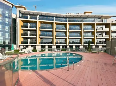 a hotel with a swimming pool in front of a building at New! Serene Studio with Balcony and Pool Crystal Res in Dubai