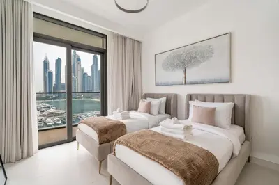 two beds in a hotel room with a large window at New! Stunning 2BR wBalcony and Pool Marina Vista in Dubai