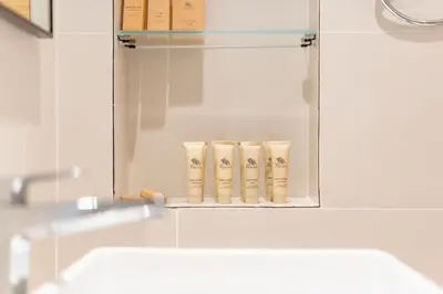 a bathroom mirror with three rolls of toilet paper at New! Stunning 2BR wBalcony and Pool Marina Vista in Dubai