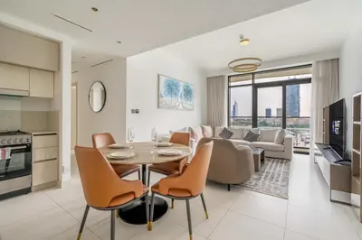 a kitchen and living room with a table and chairs at New! Stunning 2BR wBalcony and Pool Marina Vista in Dubai