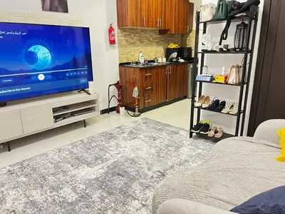 a living room with a flat screen tv and a couch at Studio in Dubai