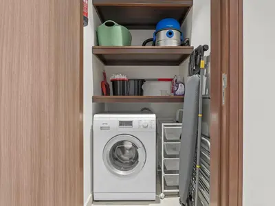 a laundry room with a washing machine in a room at Urban Compact 2BKH Sleeps 4 Full Burj Khalifa View in Dubai