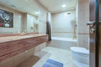 a bathroom with a toilet and a sink and a tub at Royal oceanic Dubai marina in Dubai