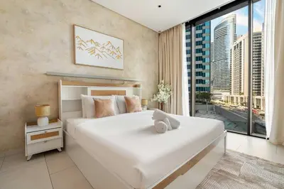 a bedroom with a large white bed and a large window at New! Spacious 2BR with Burj Views in Marquise Square in Dubai