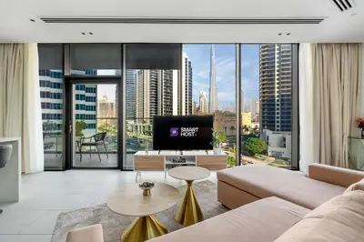 a living room with a couch and a large window at New! Spacious 2BR with Burj Views in Marquise Square in Dubai