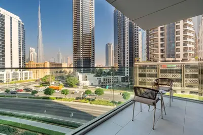 a balcony with two chairs and a view of a city at New! Spacious 2BR with Burj Views in Marquise Square in Dubai