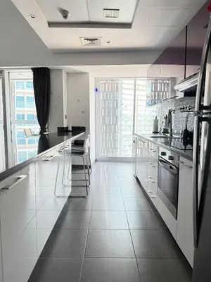 a kitchen with white counters and a large window at Cayan Tower, Dubai Marina in Dubai