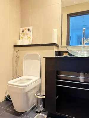 a bathroom with a white toilet and a sink at Cayan Tower, Dubai Marina in Dubai